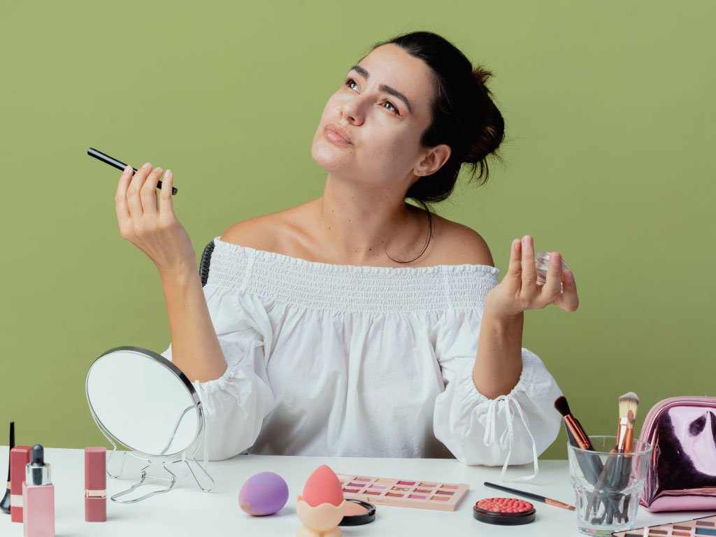Mujer sentada con sus cosméticos pensando en que maquila elegir
